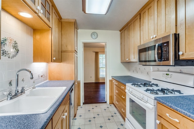 kitchen with stainless steel appliances, sink, and decorative backsplash