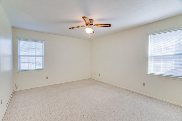 carpeted spare room with ceiling fan and a wealth of natural light