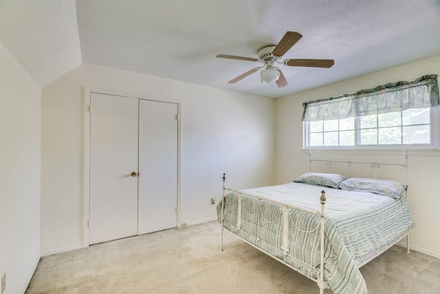 carpeted bedroom with ceiling fan and a closet