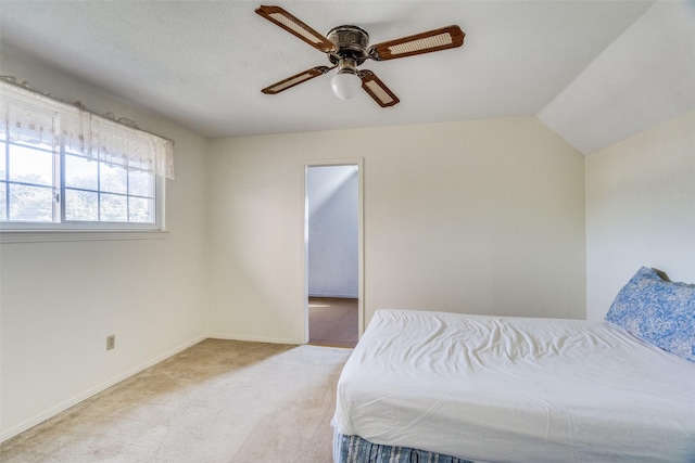 carpeted bedroom featuring ceiling fan and vaulted ceiling