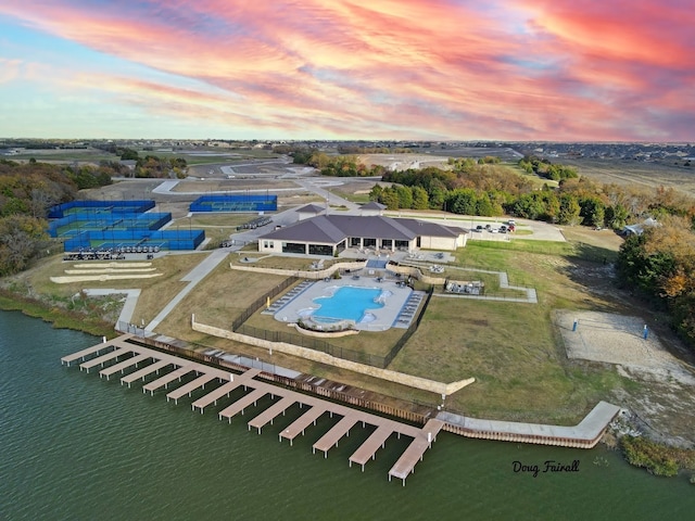 aerial view at dusk featuring a water view