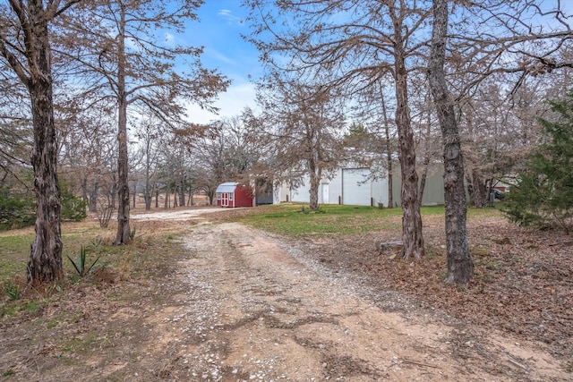 view of street with an outbuilding and dirt driveway