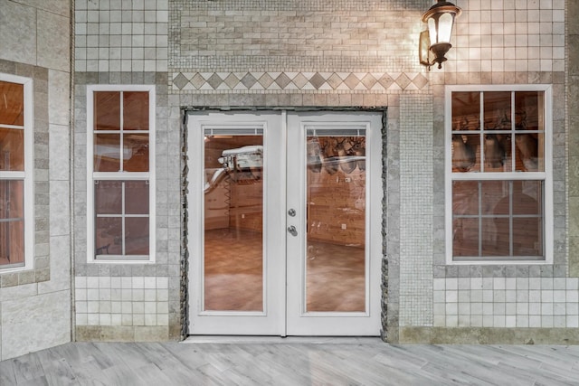 doorway to property featuring french doors and brick siding