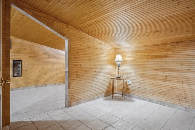 empty room with vaulted ceiling, wooden walls, and wood ceiling