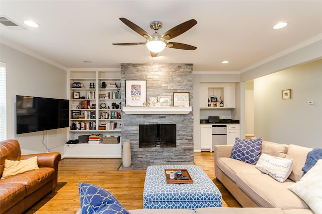 living room featuring crown molding, a fireplace, and light hardwood / wood-style flooring