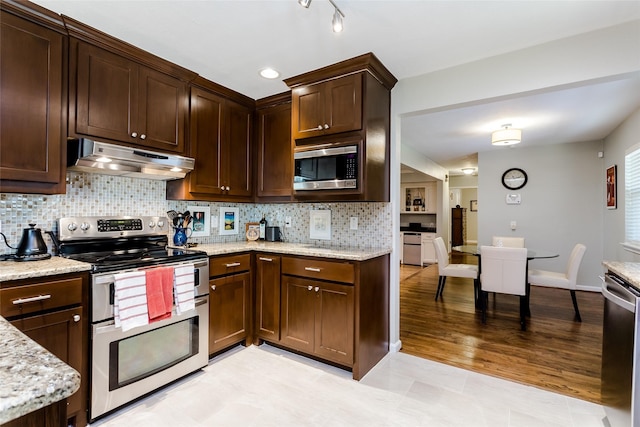 kitchen with tasteful backsplash, dark brown cabinetry, light stone countertops, and appliances with stainless steel finishes