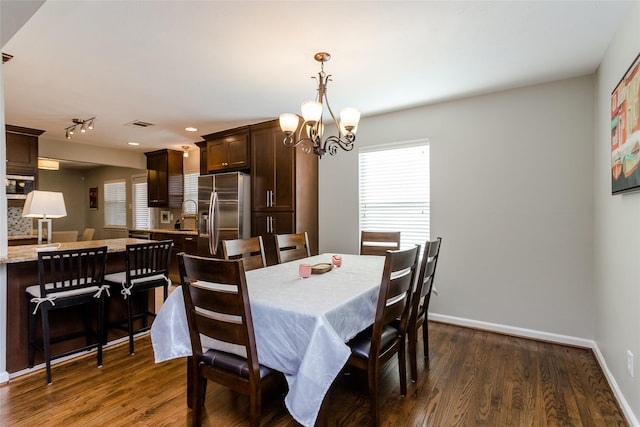 dining space featuring a notable chandelier and dark hardwood / wood-style floors