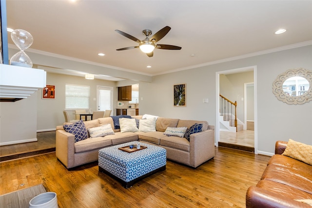 living room featuring hardwood / wood-style flooring, crown molding, and ceiling fan