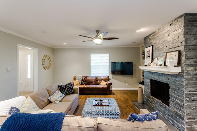 living room featuring hardwood / wood-style floors, crown molding, a fireplace, and ceiling fan