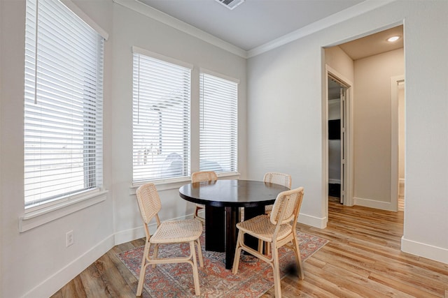 dining room featuring crown molding and light wood-type flooring