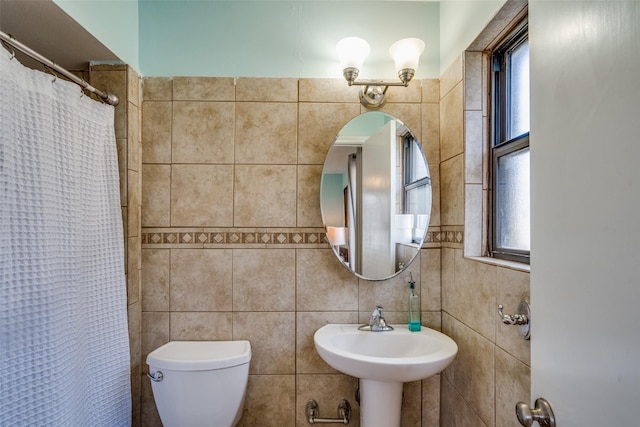 1241 Cypress Dr, Richardson, TX 75080 - bathroom featuring toilet, tile walls, a sink, and plenty of natural light