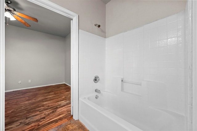 bathroom featuring ceiling fan, wood-type flooring, and tub / shower combination