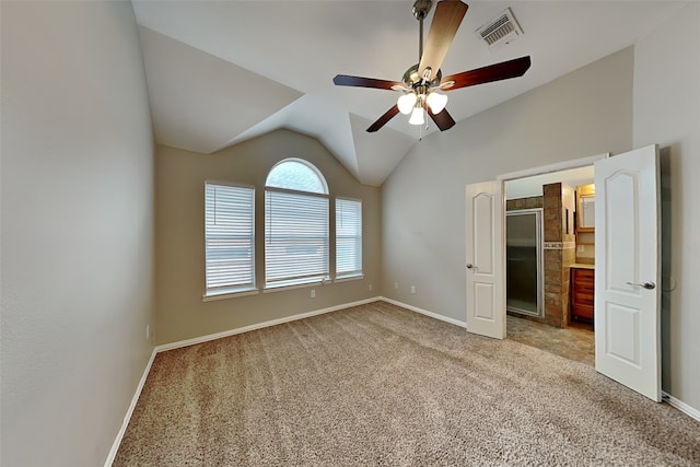 unfurnished bedroom with ceiling fan, vaulted ceiling, and light carpet