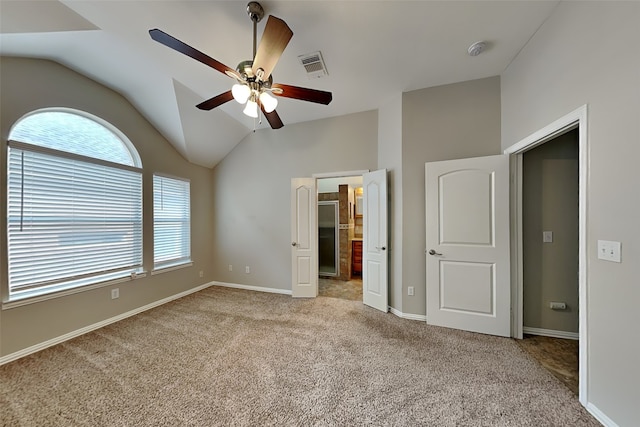 unfurnished bedroom featuring multiple windows, ceiling fan, vaulted ceiling, and light carpet