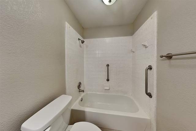 bathroom with tiled shower / bath combo, a textured ceiling, and toilet