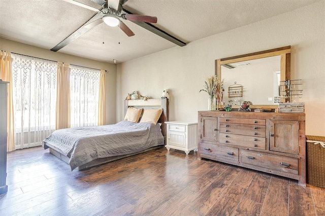 bedroom with dark wood-type flooring, ceiling fan, and a textured ceiling