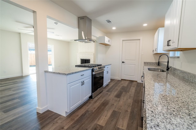 kitchen with white cabinetry, sink, island range hood, and stainless steel gas stove