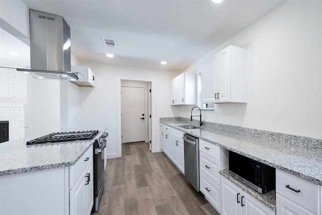 kitchen featuring appliances with stainless steel finishes, island range hood, sink, and white cabinets