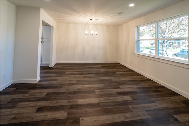 unfurnished dining area featuring dark hardwood / wood-style flooring and an inviting chandelier