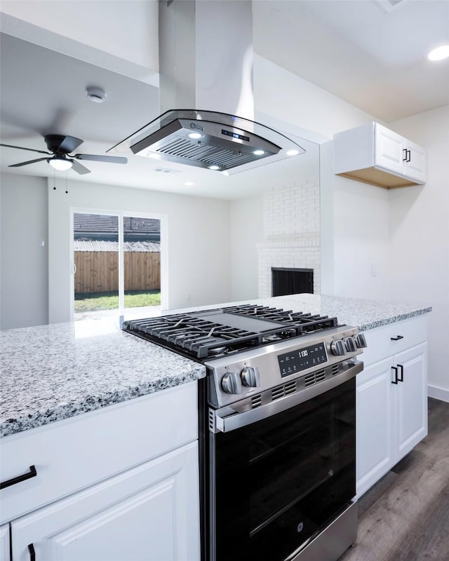 kitchen with white cabinetry, dark wood-type flooring, island range hood, and gas stove