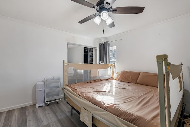 bedroom featuring hardwood / wood-style flooring, crown molding, and ceiling fan