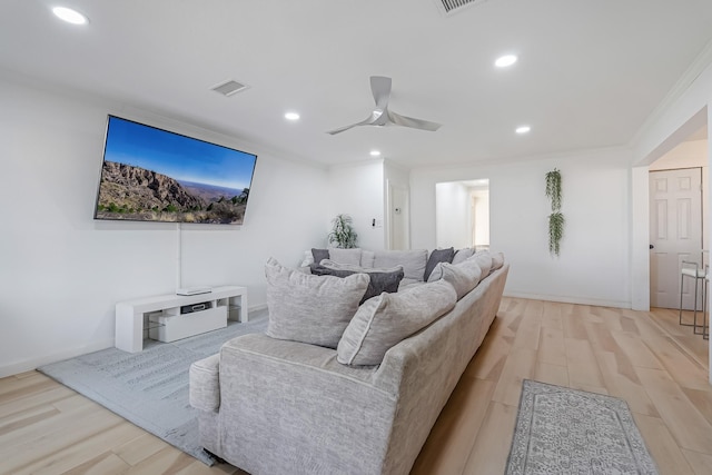 living room featuring crown molding, ceiling fan, and light hardwood / wood-style flooring