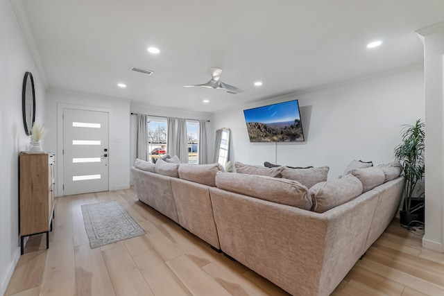 living room with crown molding, ceiling fan, and light hardwood / wood-style flooring