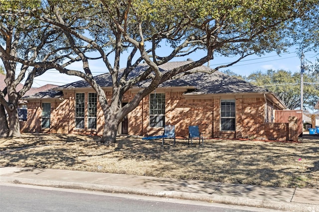 single story home featuring brick siding