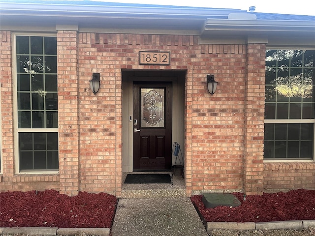 view of exterior entry featuring brick siding