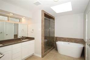 bathroom with vanity and shower with separate bathtub