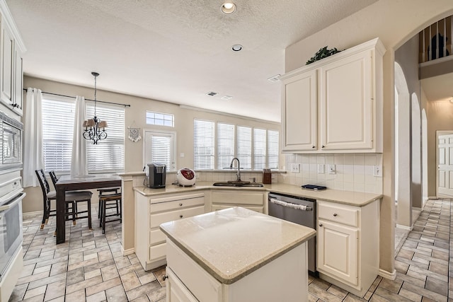 kitchen with hanging light fixtures, white cabinetry, appliances with stainless steel finishes, and a center island