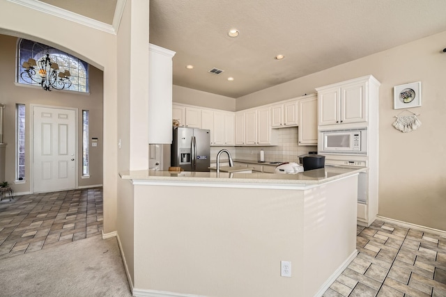 kitchen with white cabinetry, kitchen peninsula, white microwave, and stainless steel fridge with ice dispenser