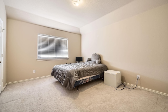 bedroom with light carpet and refrigerator