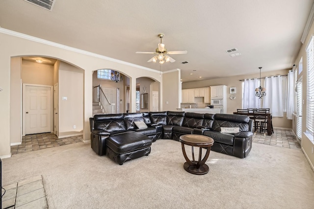 living room featuring light carpet, ceiling fan with notable chandelier, and ornamental molding