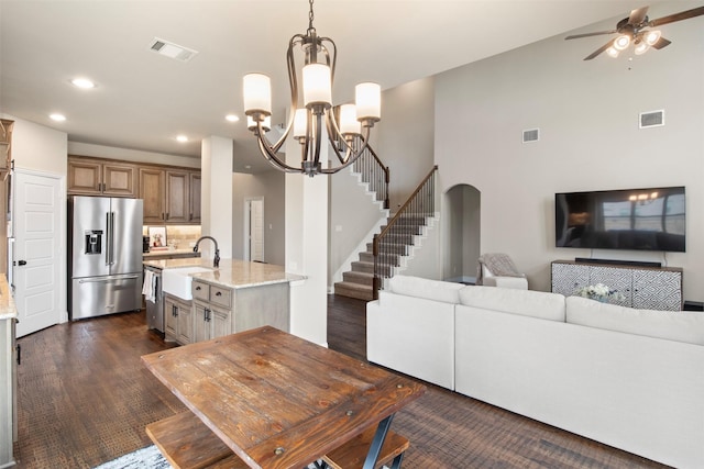 living room featuring dark hardwood / wood-style flooring, sink, and ceiling fan with notable chandelier