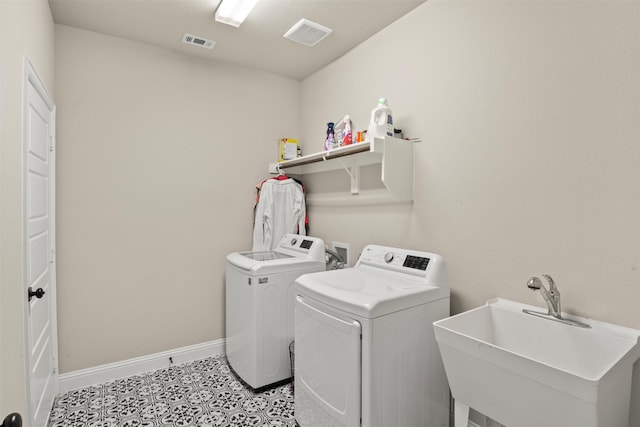 clothes washing area with independent washer and dryer, sink, and light tile patterned floors