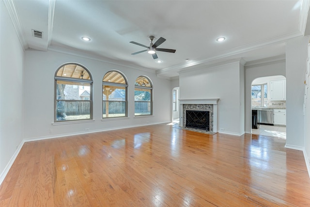 unfurnished living room with crown molding, a wealth of natural light, ceiling fan, and light hardwood / wood-style floors