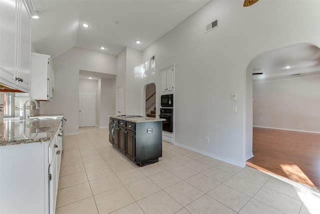 kitchen featuring white cabinetry, a center island, sink, and black appliances