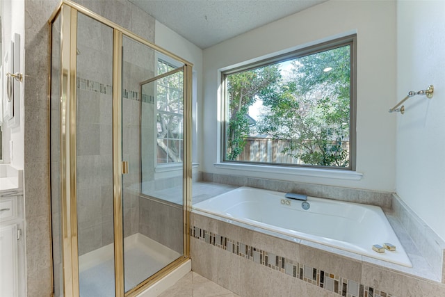 bathroom with vanity, independent shower and bath, tile patterned flooring, and a textured ceiling