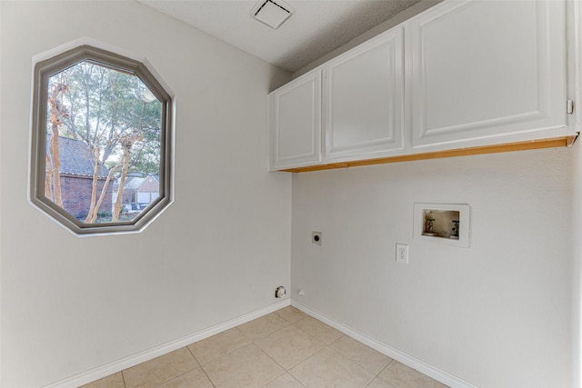 laundry area featuring light tile patterned flooring, cabinets, a textured ceiling, hookup for a washing machine, and electric dryer hookup