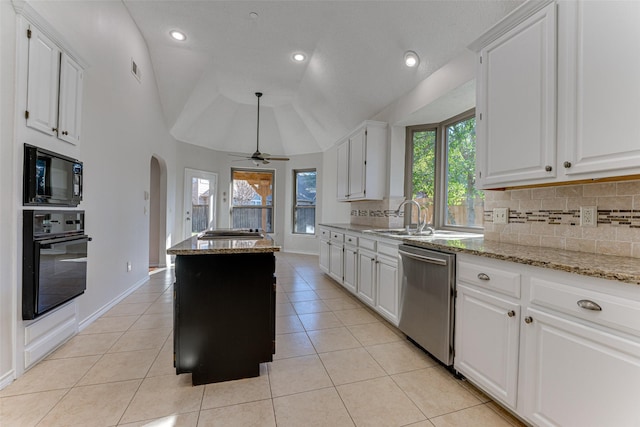 kitchen with sink, white cabinetry, light tile patterned floors, light stone countertops, and black appliances