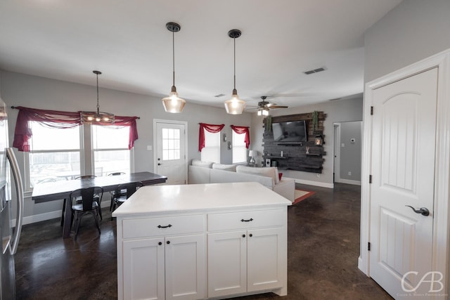 kitchen featuring white cabinetry, pendant lighting, a center island, and ceiling fan