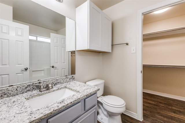 bathroom featuring vanity, hardwood / wood-style floors, toilet, and walk in shower