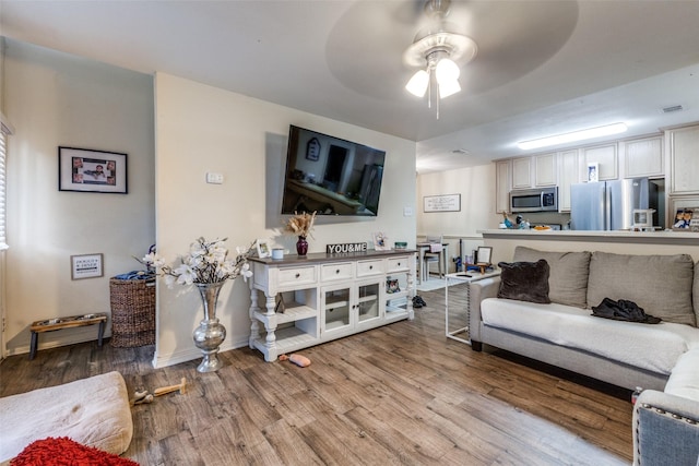 living room featuring ceiling fan and light hardwood / wood-style flooring