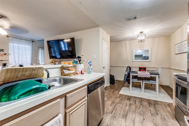 kitchen featuring stainless steel appliances, sink, light hardwood / wood-style floors, and light brown cabinets