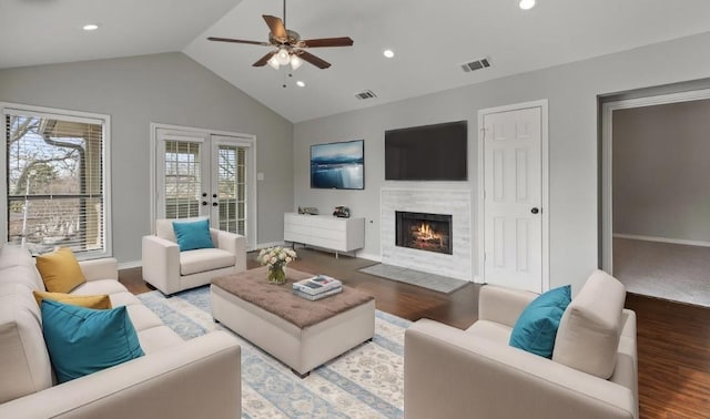 living room with lofted ceiling, hardwood / wood-style floors, french doors, and ceiling fan