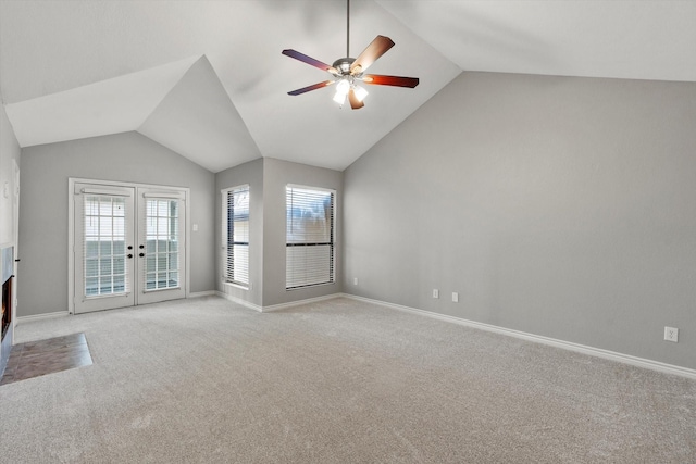 unfurnished living room featuring light carpet, vaulted ceiling, and french doors