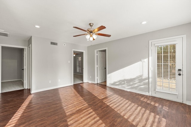 spare room with dark hardwood / wood-style flooring and ceiling fan