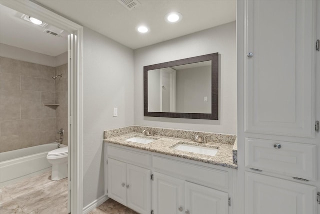 full bathroom featuring tiled shower / bath, vanity, and toilet