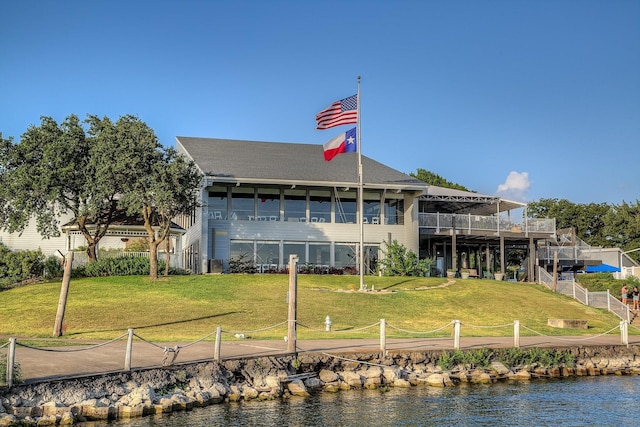 back of house featuring a water view and a yard